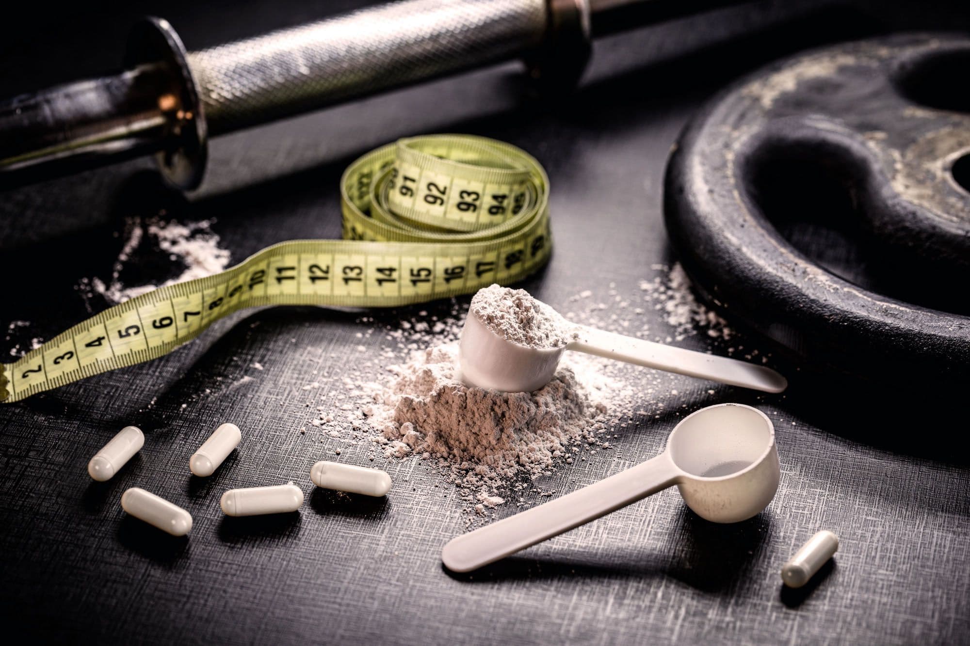 Supplement capsules and powder with gym weights