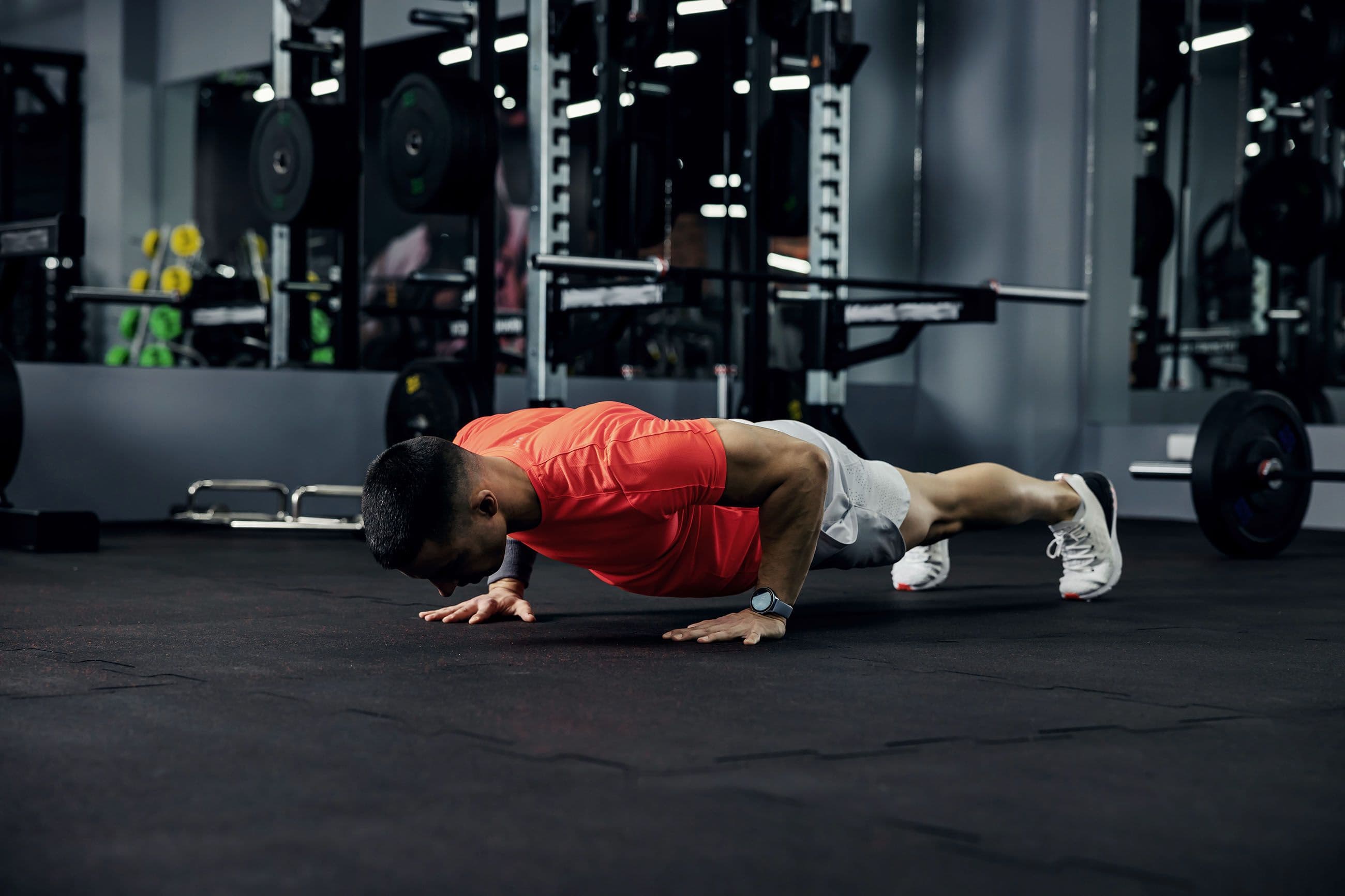 guy doing push-ups in a darkened gym